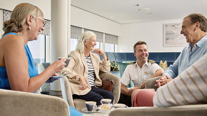 Captain Kim Tanner meeting with guests in the Britannia Lounge on Spirit of Adventure